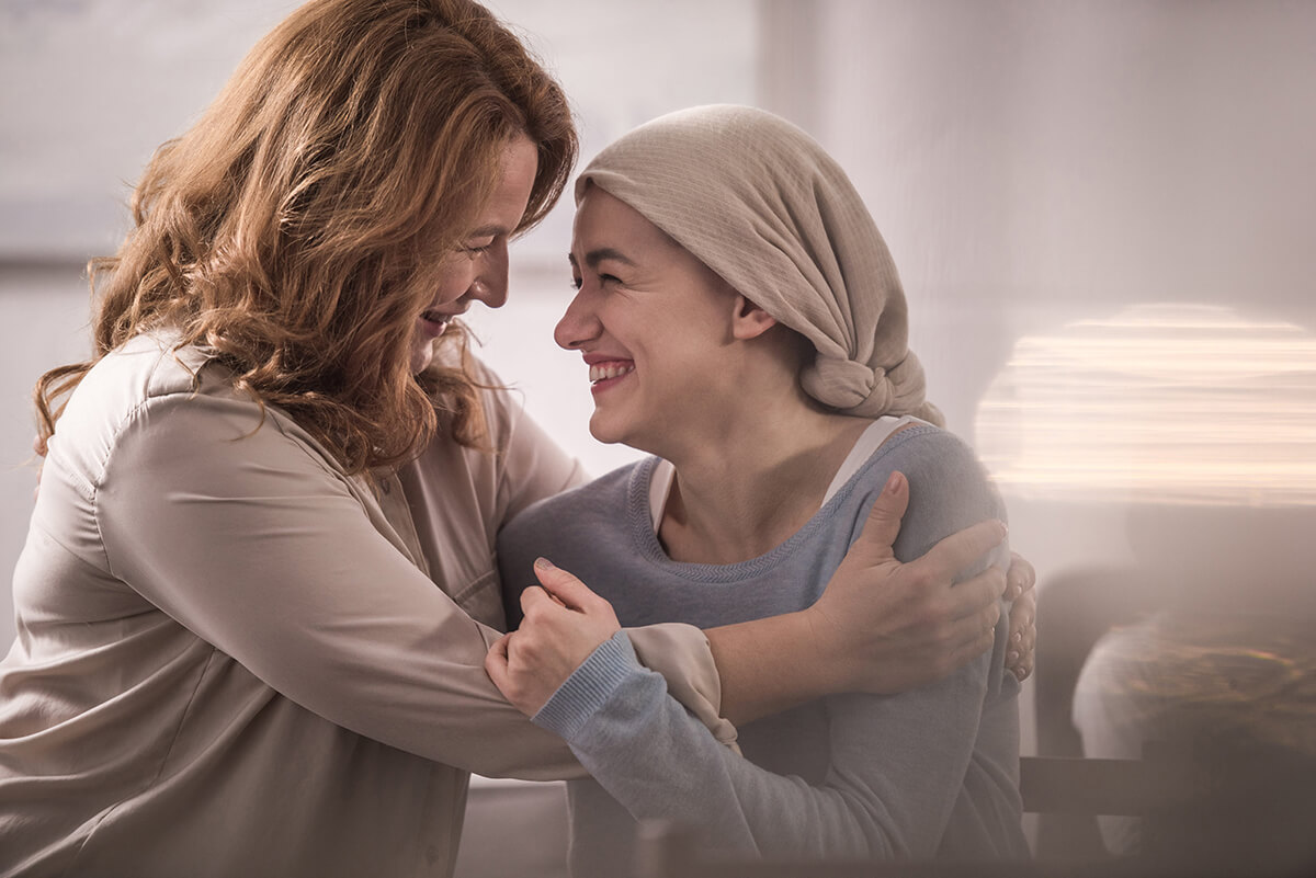 Woman embracing a loved one undergoing cancer treatment, representing emotional support and financial peace of mind during recovery.