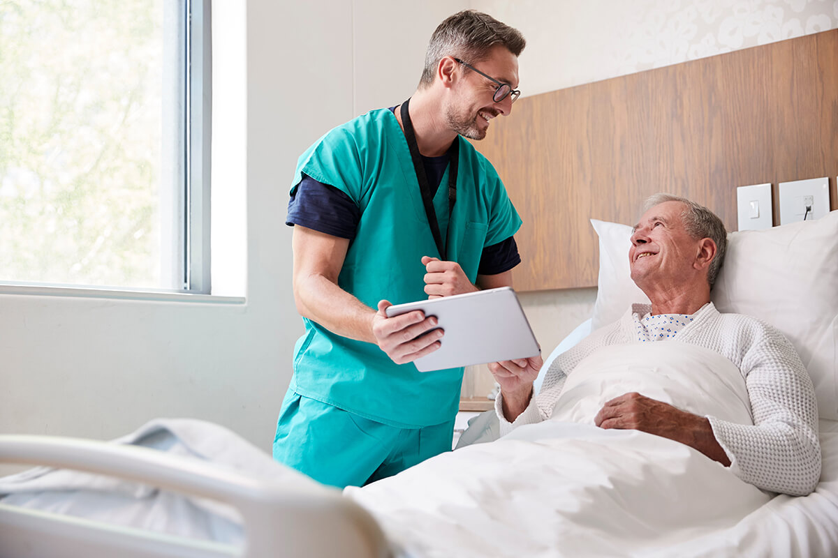 Healthcare professional visiting a cancer patient in a hospital room, representing compassionate care and financial support during treatment and recovery.