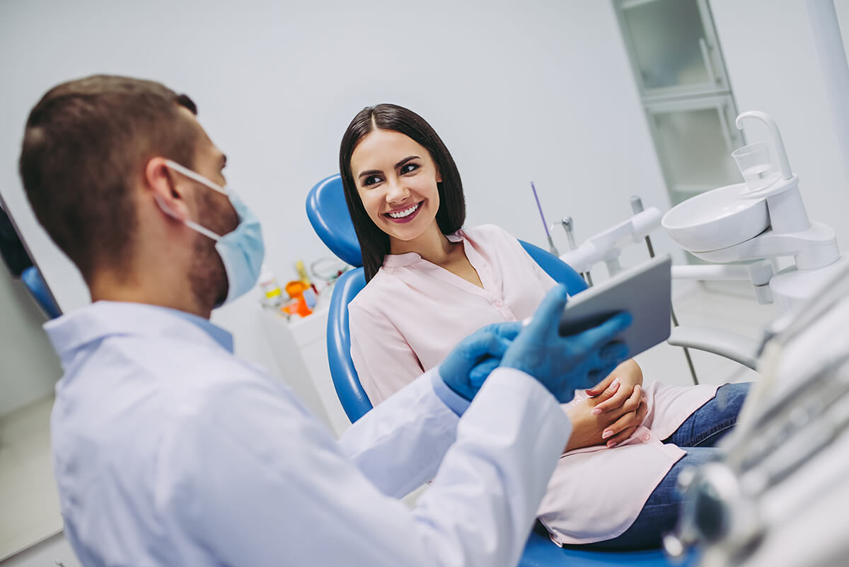 Dentist discussing treatment options with a smiling patient during a routine dental visit.